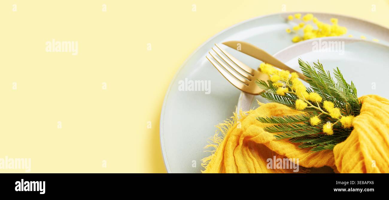 Romantic spring table decor with mimosa and ceramic plates Stock Photo