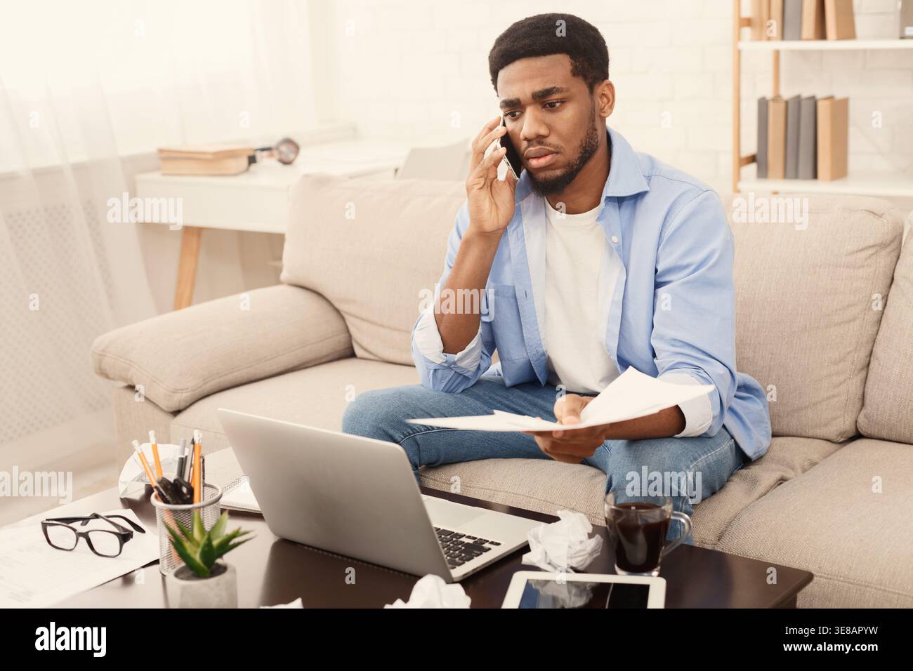 Serious man talking on phone and reading document Stock Photo