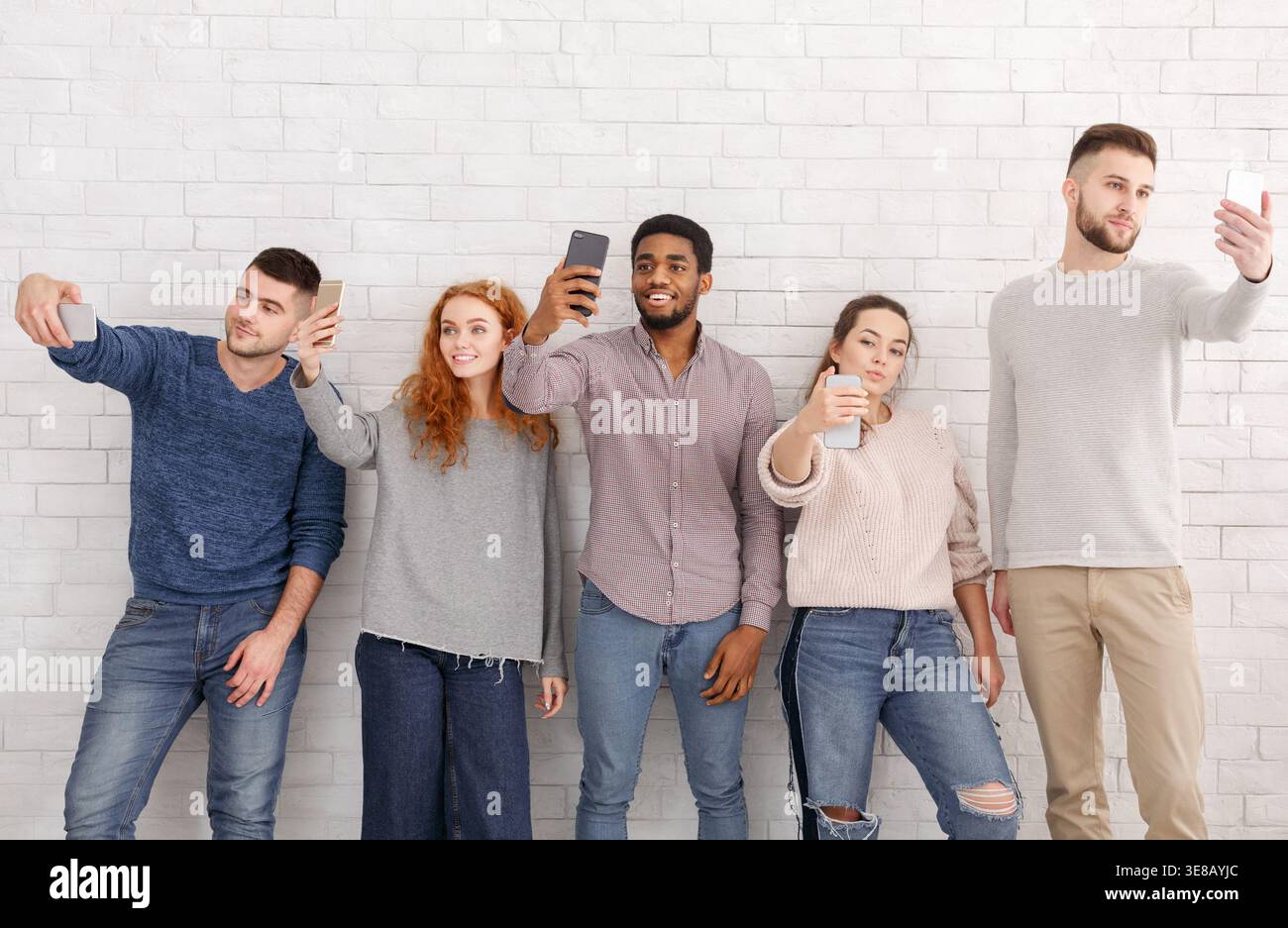 Young people taking selfies on their smartphones Stock Photo