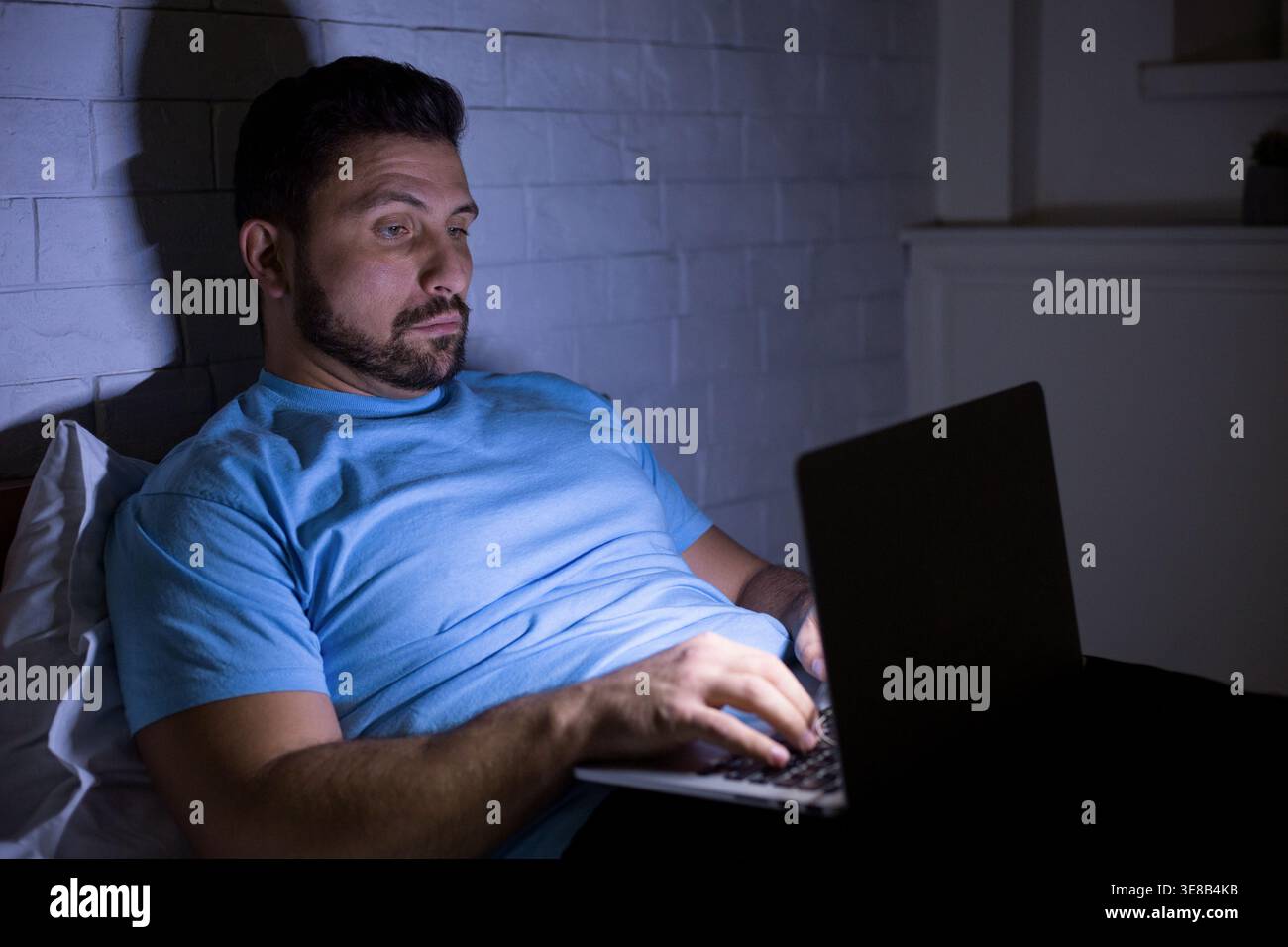Man using laptop computer doing hard work at night Stock Photo