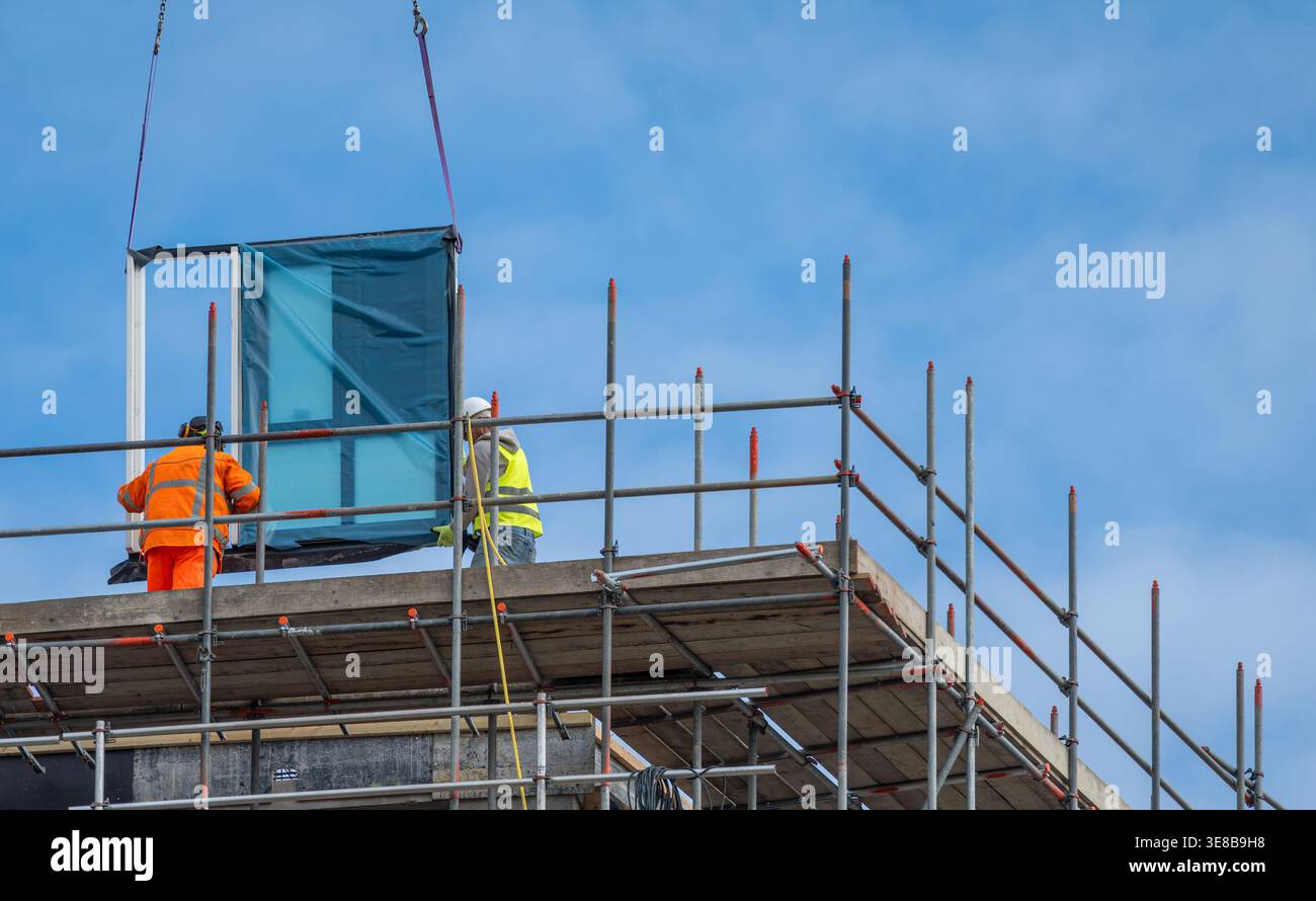 Construction workers at modern high-rise building site, urban development and engineering industry concept Stock Photo