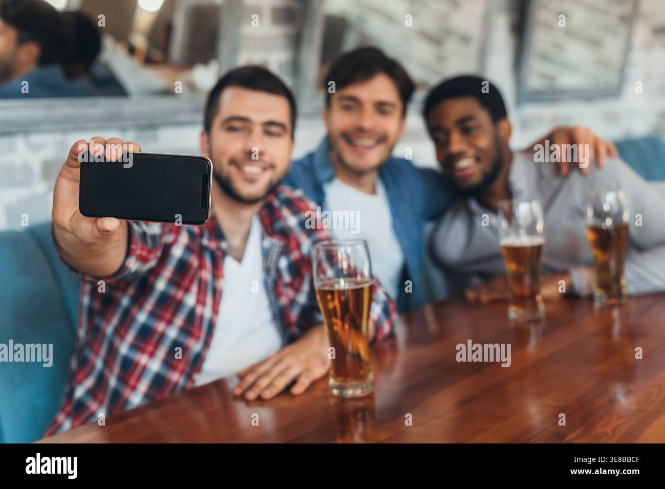 Men taking selfie and drinking beer in bar Stock Photo