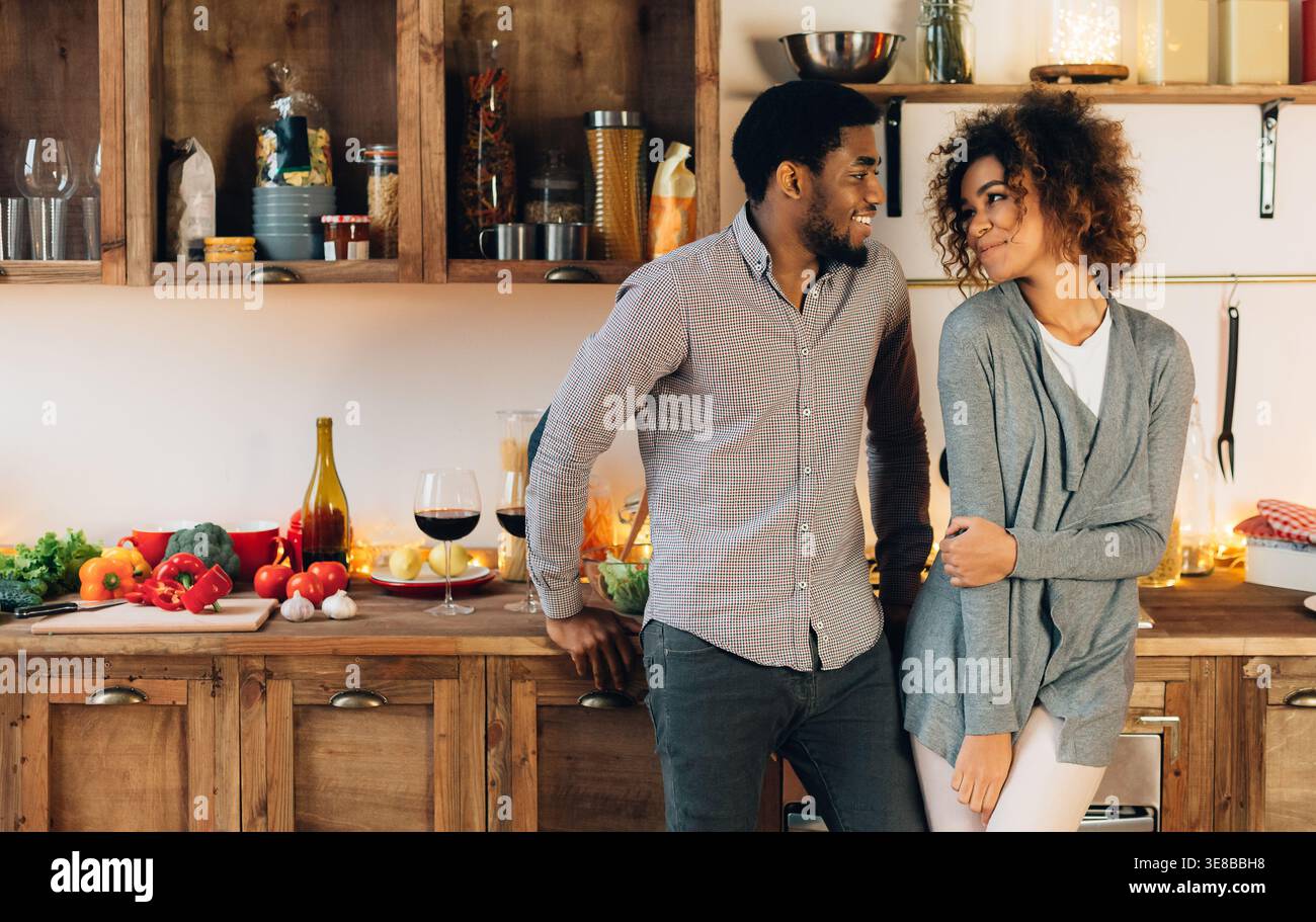 Lovely black couple standing in cozy kitchen Stock Photo
