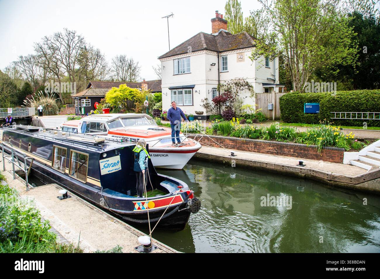 Pleasure cruiser and narrowboat side by side passing through Marlow lock on the river Thames as they pass through the Buckinghamshire town of Marlow Stock Photo