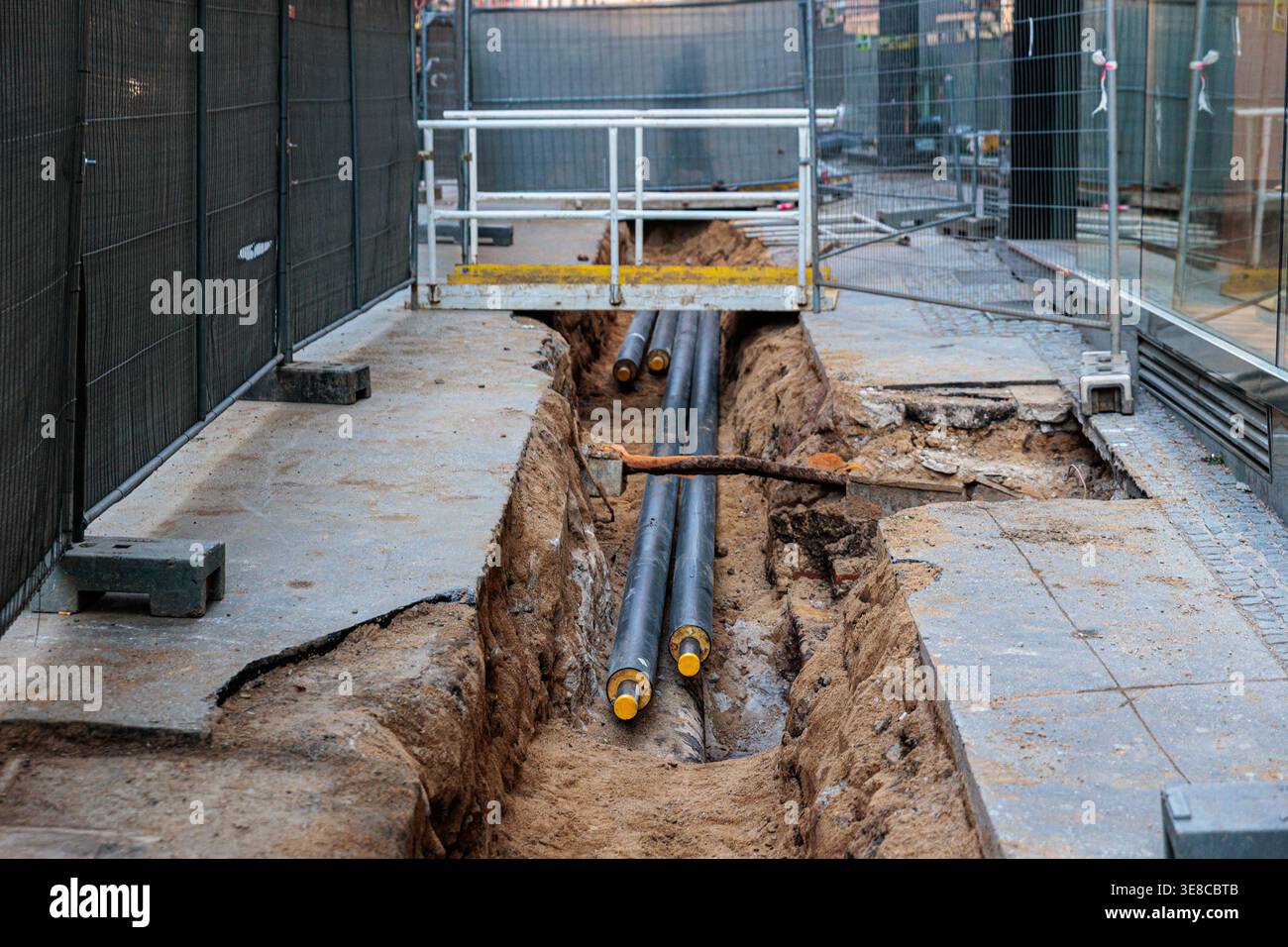 Urban/street Runder An urban street under construction showing an open trench with exposed ...