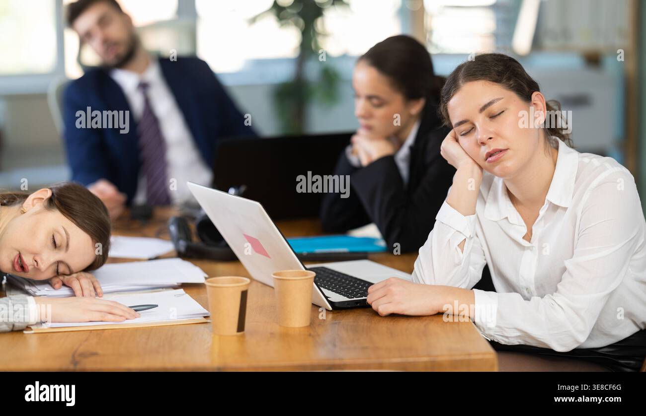 Group of tired colleagues working on laptop Stock Photo