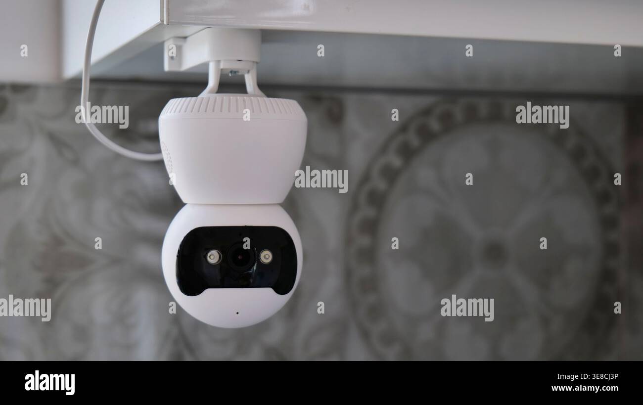 White Indoor Security Camera Mounted on Ceiling Stock Photo