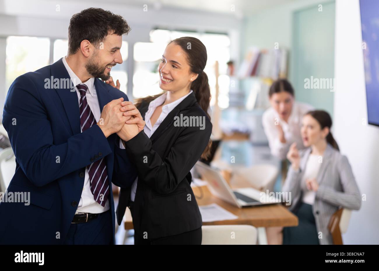 Man and woman holding hands in office Stock Photo