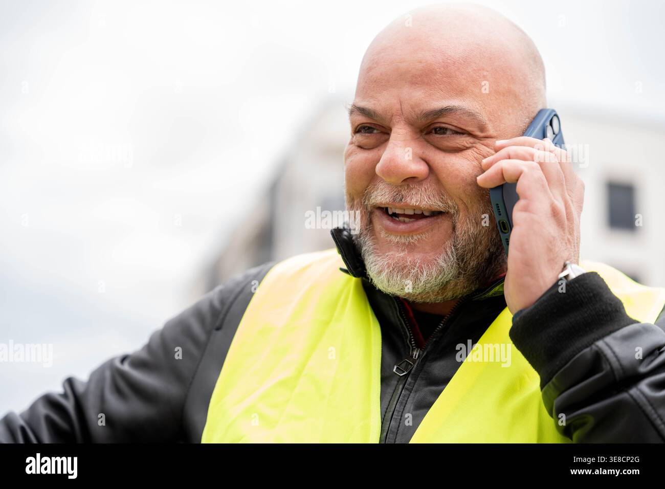 Bearded man communicating with smartphone while standing outdoors Stock Photo