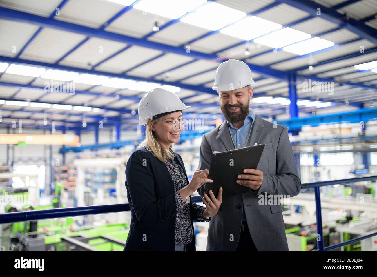 Industrial team analyzing data in high tech manufacturing plant. Stock Photo