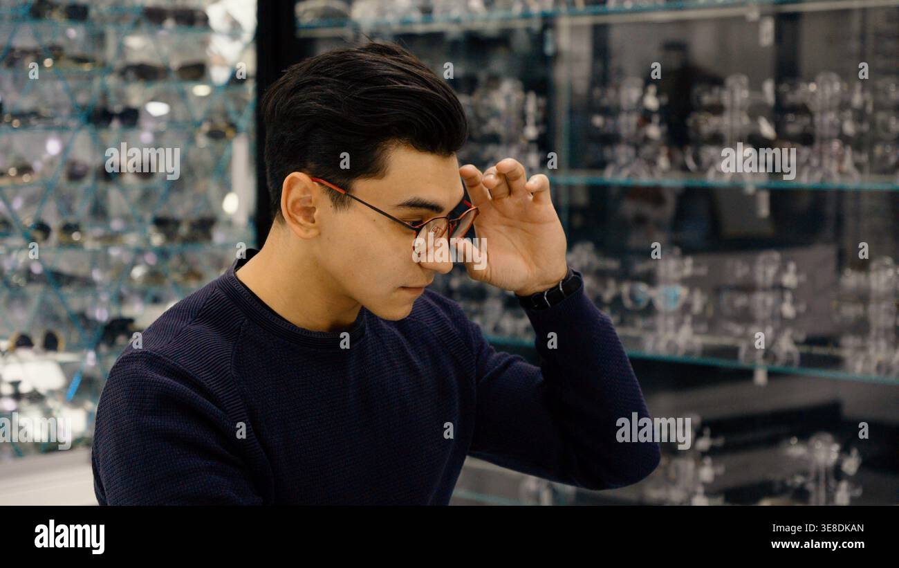 Confused man with glasses touching head and thinking Stock Photo