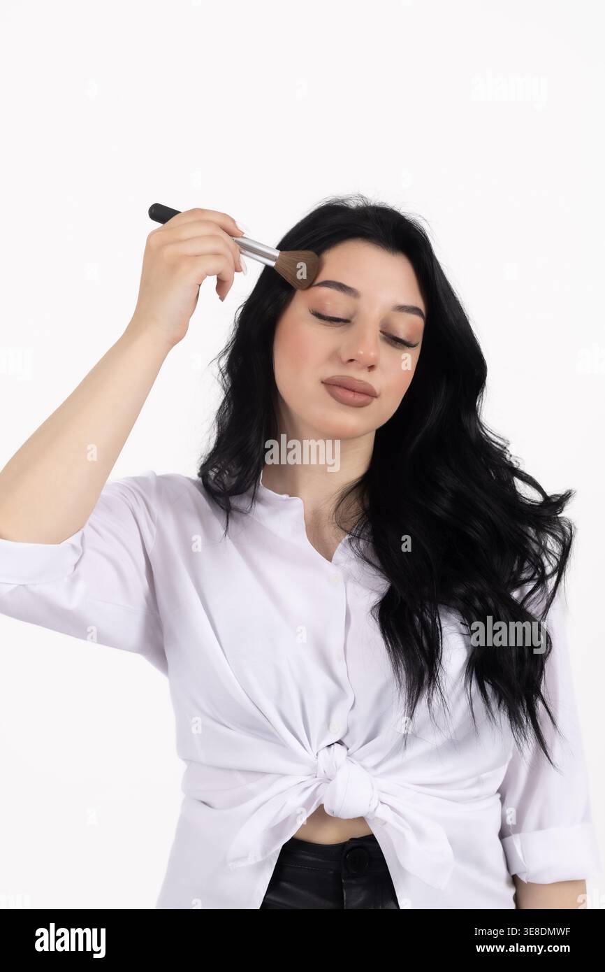 Woman applying powder with a makeup brush Stock Photo