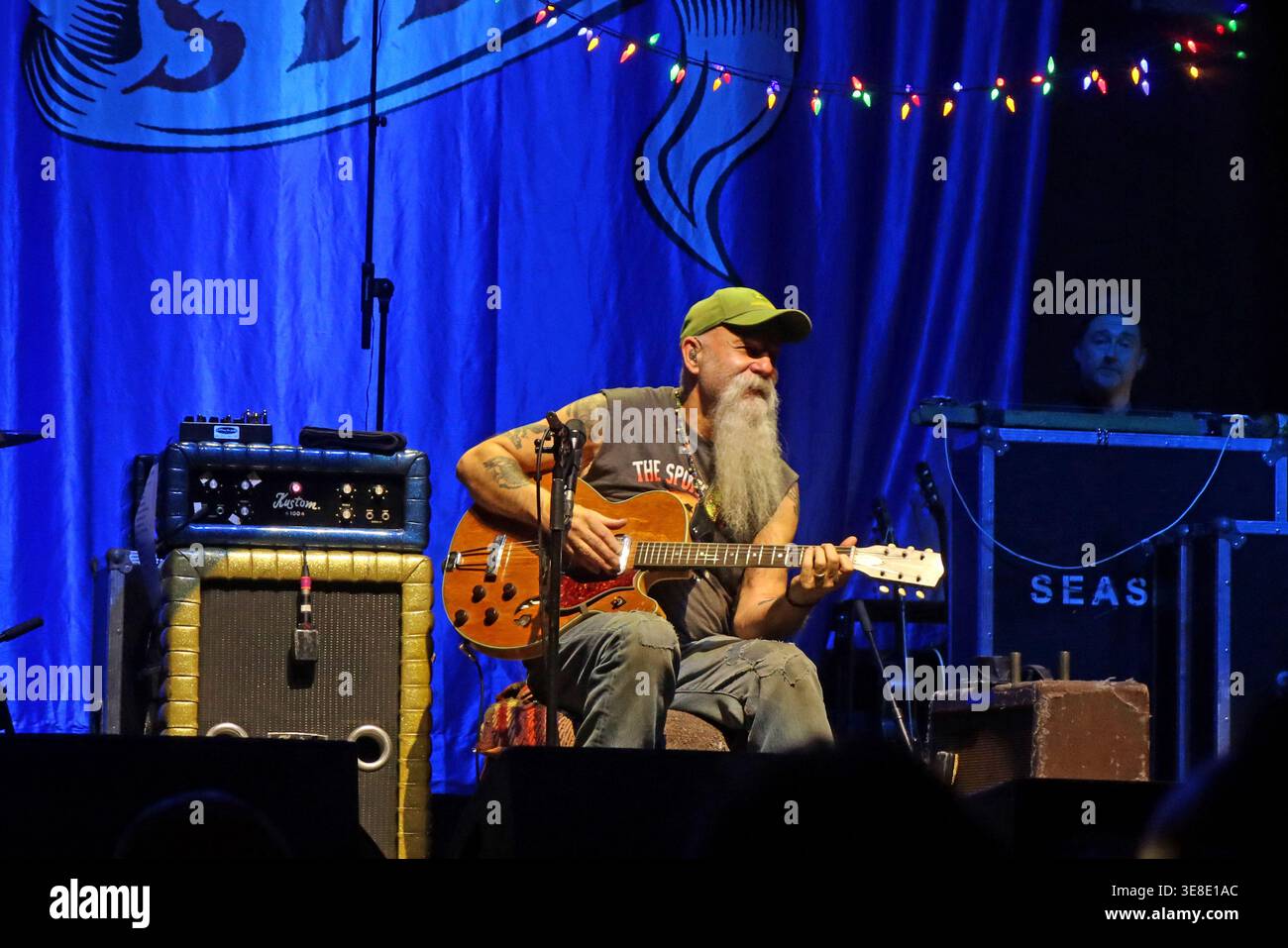 Seasick Steve performing live on stage in Albert Hall Manchester,seated with electric guitar under blue lighting during an intimate indoor concert set Stock Photo