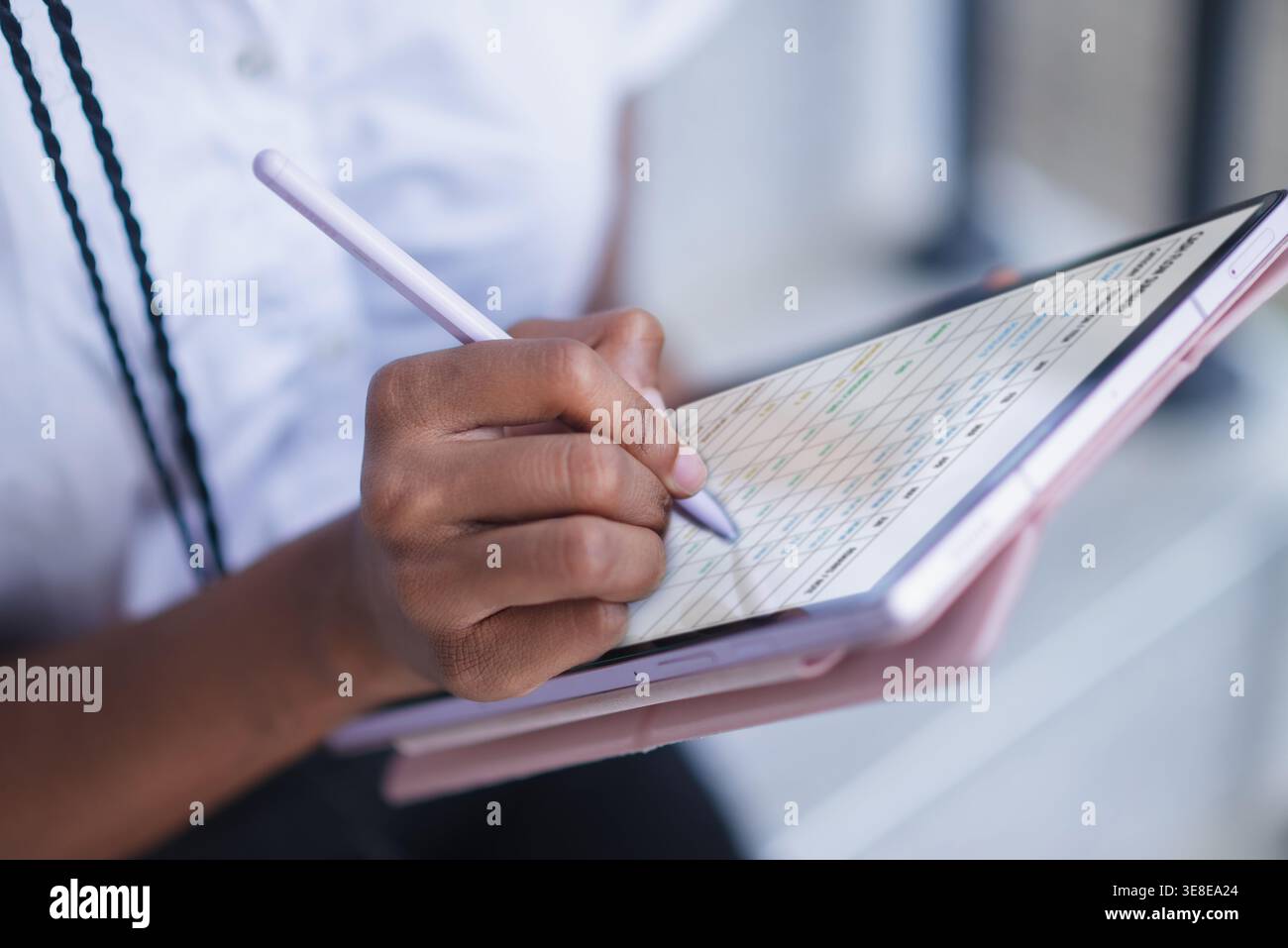 Close up of hand using stylus on tablet with digital planner interface. Schedule management, note taking, online organization, remote work, data entry Stock Photo