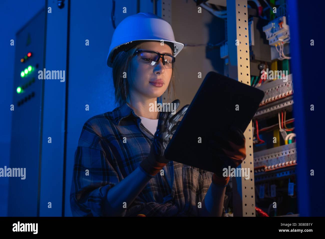 Electrical specialist inspecting power system with tablet device. Engineering control. Stock Photo