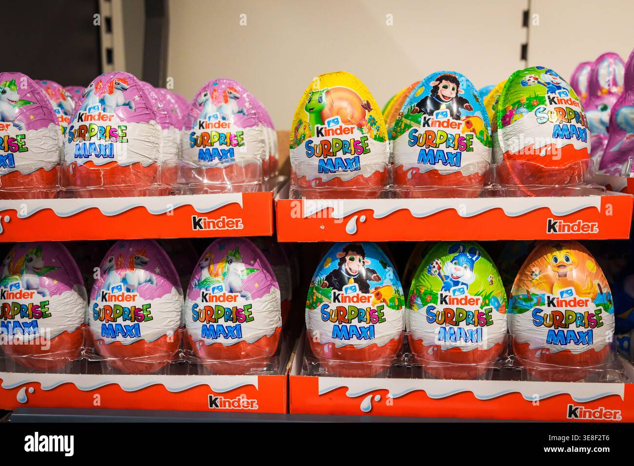 RIGA, LATVIA. 12th March 2026. A retail display featuring several rows of Kinder Surprise Maxi chocolate eggs in colorful foil packaging. The large ch Stock Photo