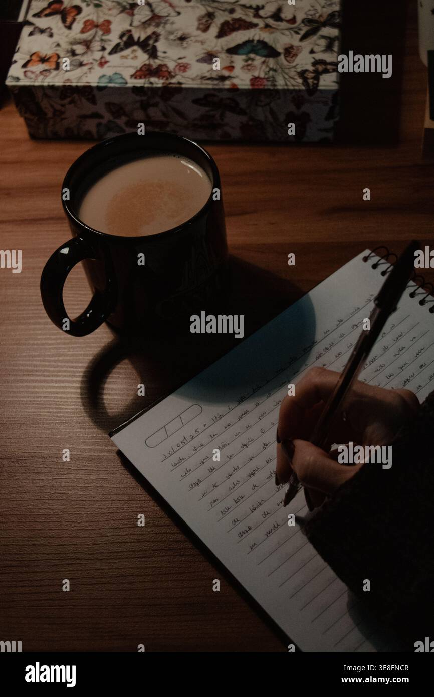 Hand Writing in Notebook with Coffee Stock Photo