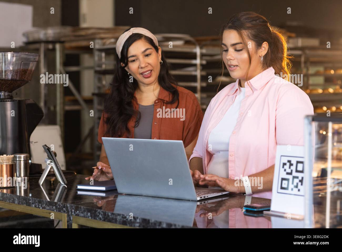 Open laptop is resting on glossy marble counter at bakery service area ...