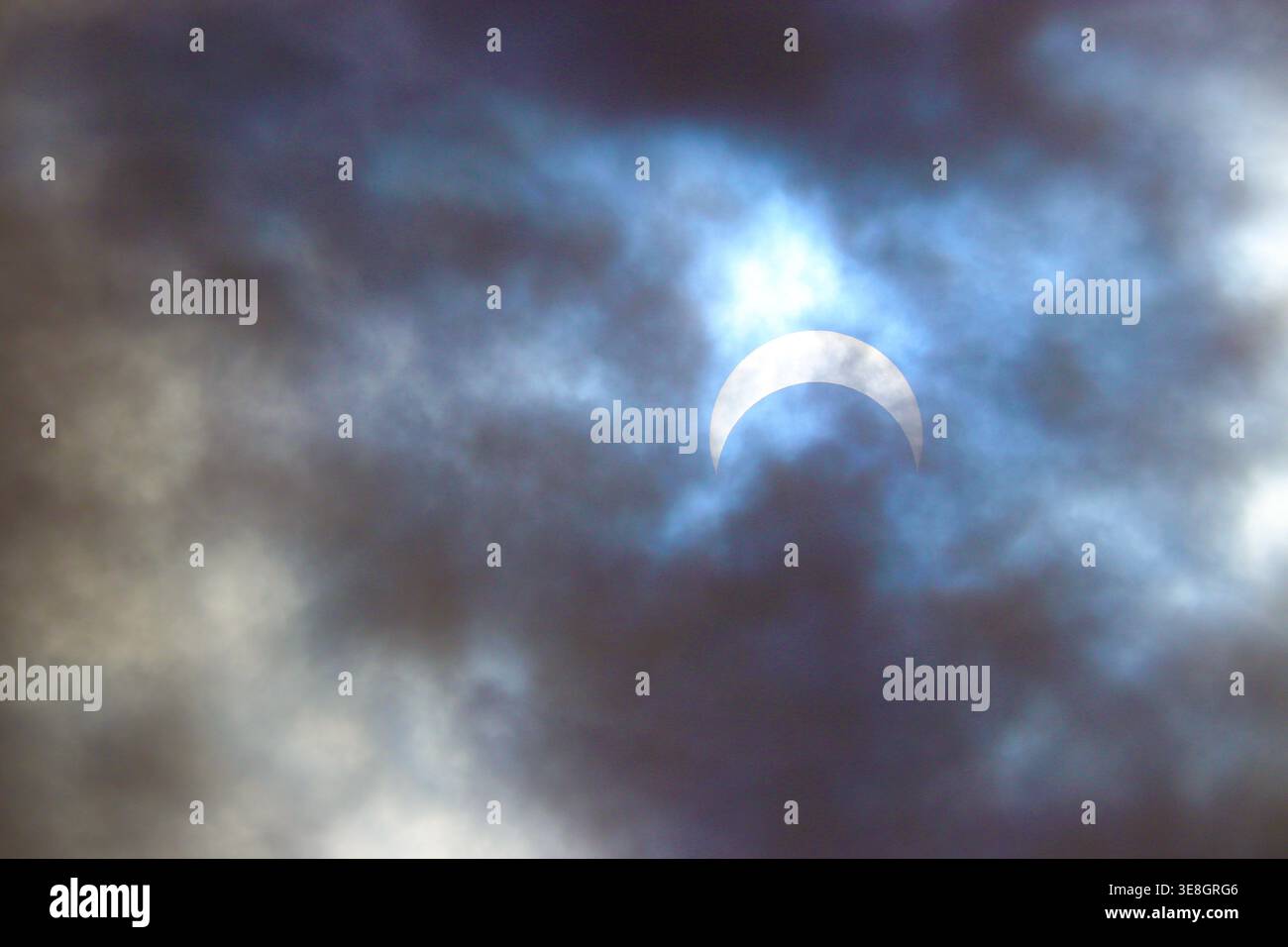 Partial solar eclipse viewed through dramatic clouds in Boise, Idaho on October 14, 2023. Stock Photo