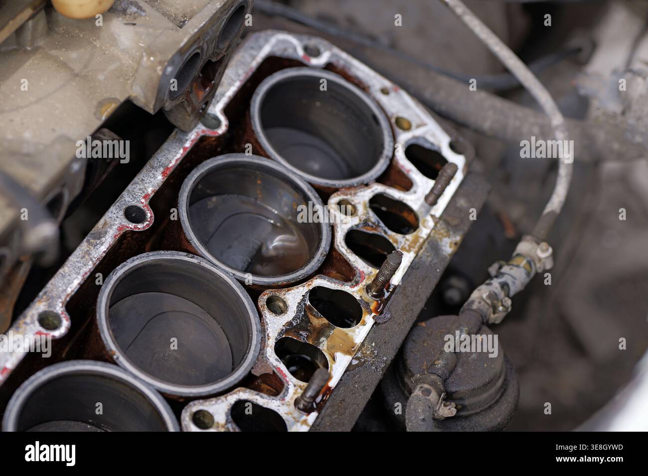 Four-cylinder engine block with removed cylinder head showing pistons ...