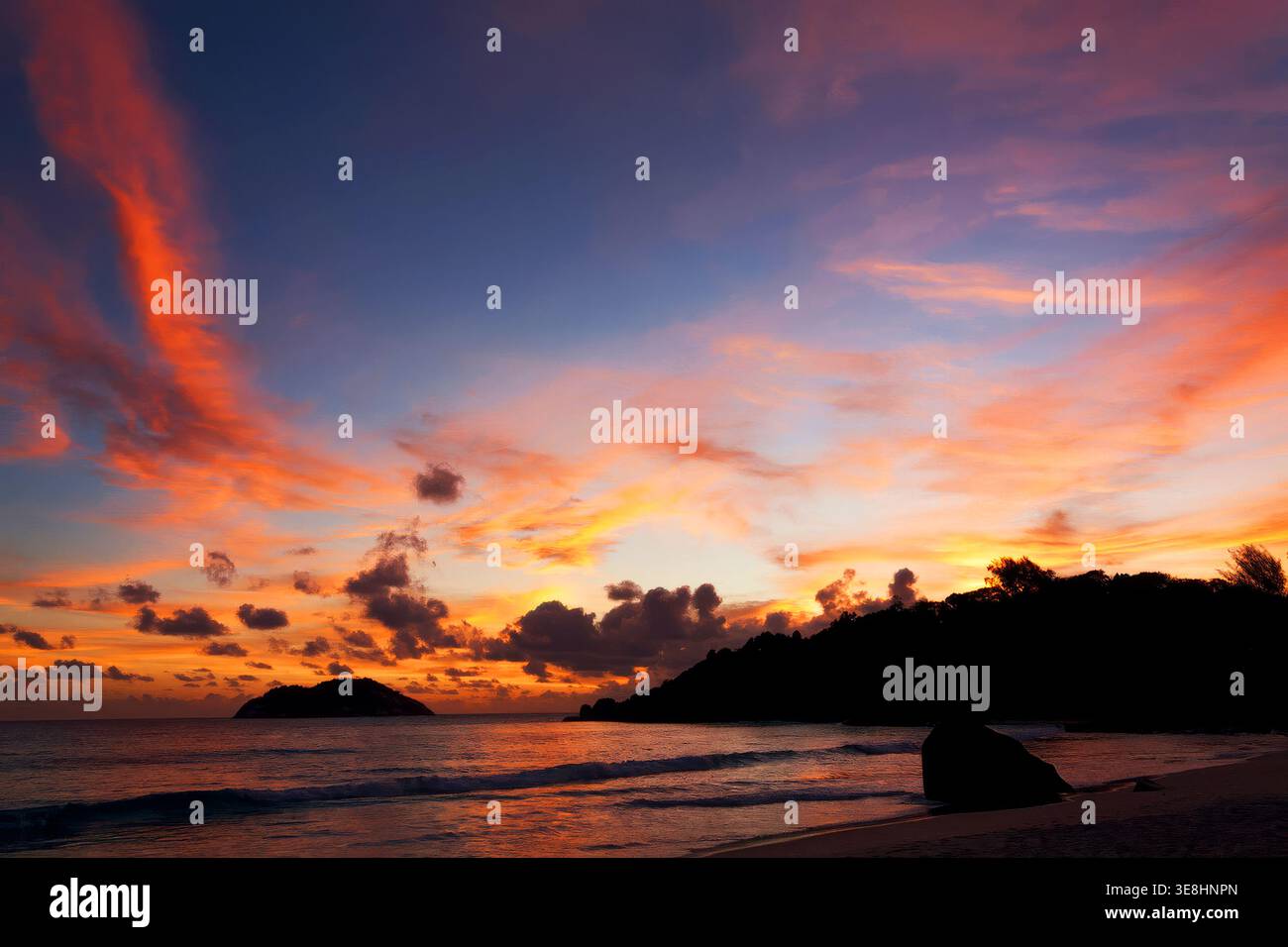 Dramatic colorful sunset sky over tropical coastline on Mahe Island, Seychelles Stock Photo