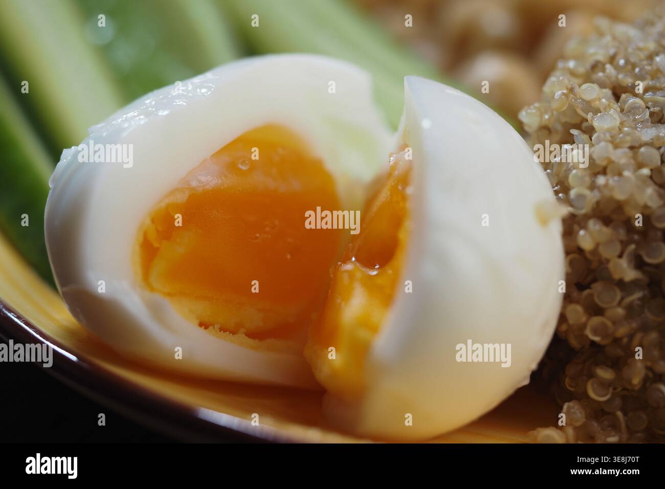 Egg yolk shown in soft boiled egg on a plate with salad Stock Photo