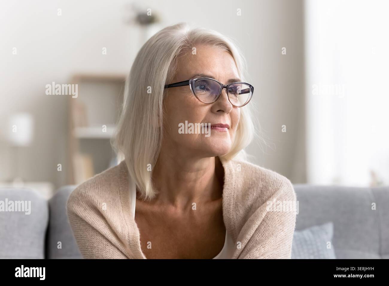Middle-aged woman looking into distance with thoughtful and reflective expression Stock Photo