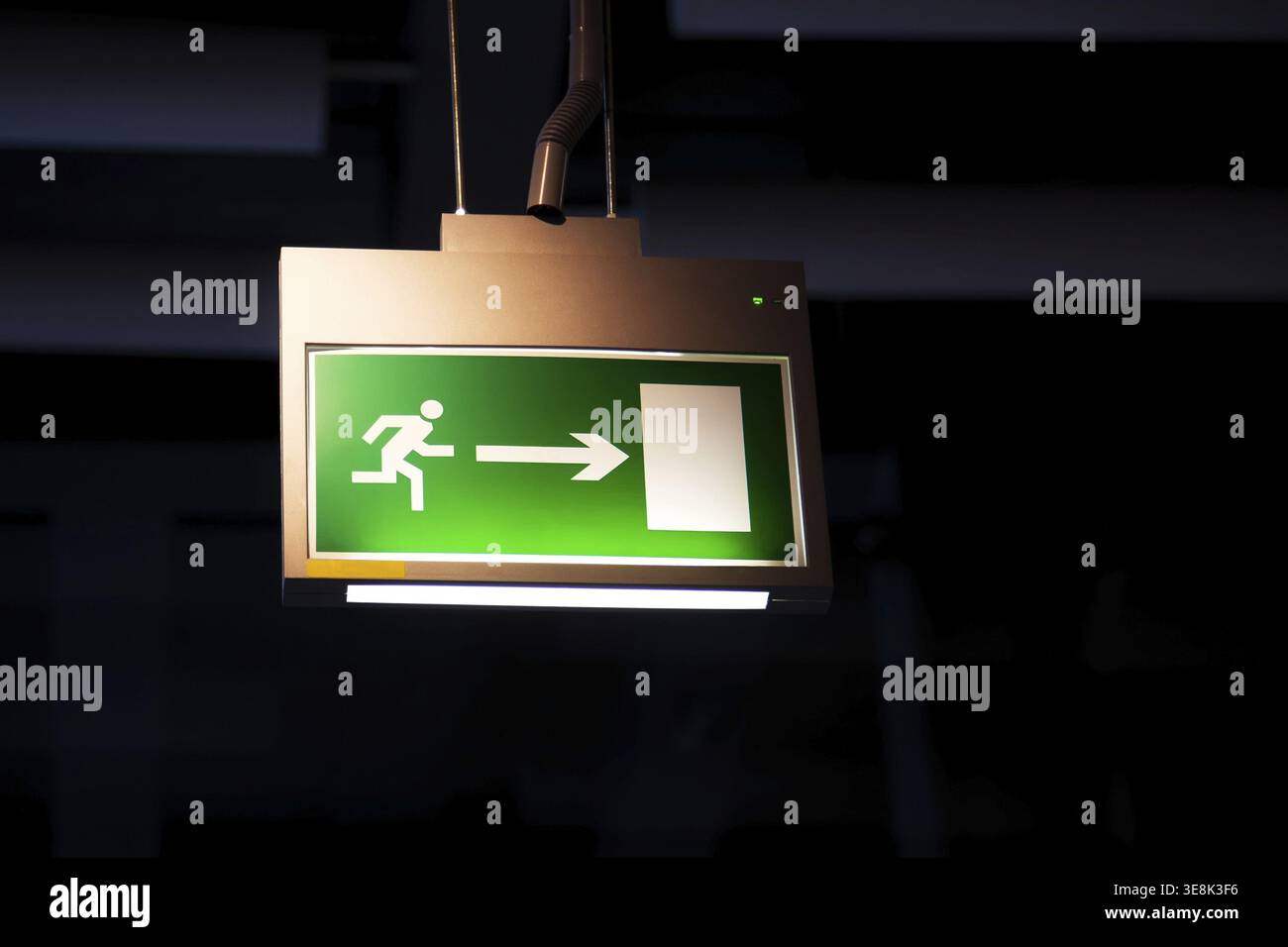 Emergency exit, illuminated green board Stock Photo