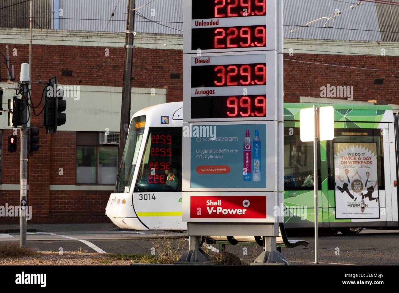 A tram is seen driving past a petrol station, with fuel price boards ...