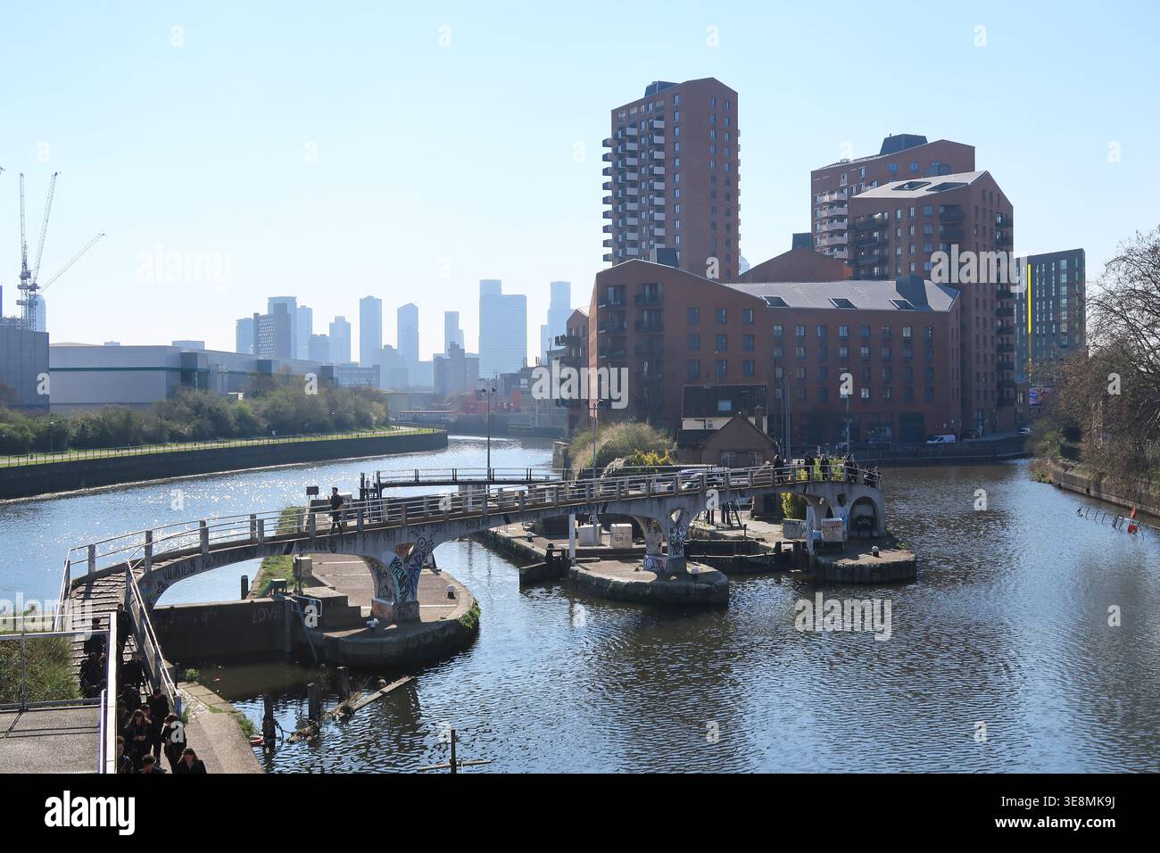 Bow Locks in London's east end, where the Limehouse Cut canal (right) meets the River Lea (left). View south, Canary Wharf towers in background. Stock Photo