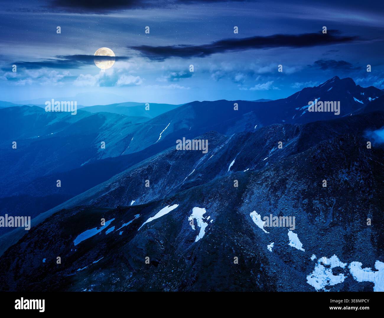 mountain scenery in summer at night. gorgeous mountainous landscape. background with rocky cliffs and grassy hillsides under a cloudy sky. full moon o Stock Photo