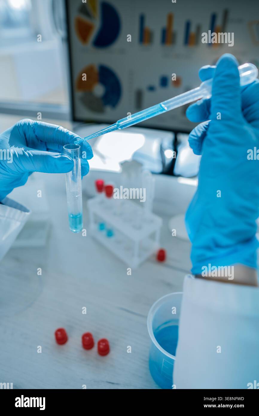 Close up hands in protective gloves performing chemical experiment with ...