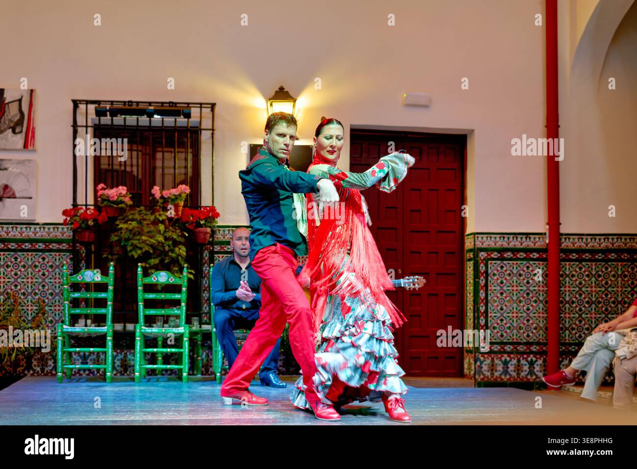 Dancers showcase flamenco in a venue in Seville, capturing the passion of this traditional Spanish art form. Audience enjoys the lively performance. Stock Photo