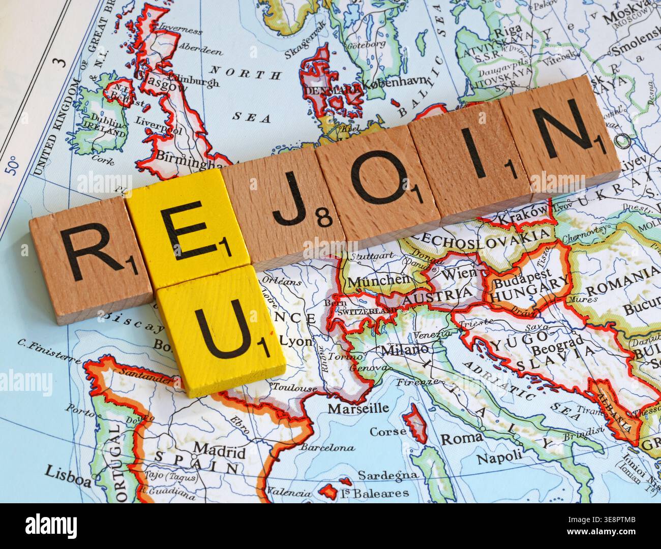 Rejoin EU message spelled out with Scrabble-style wooden letters on a map of Europe,illustrating the political debate over Britain returning to the EU Stock Photo