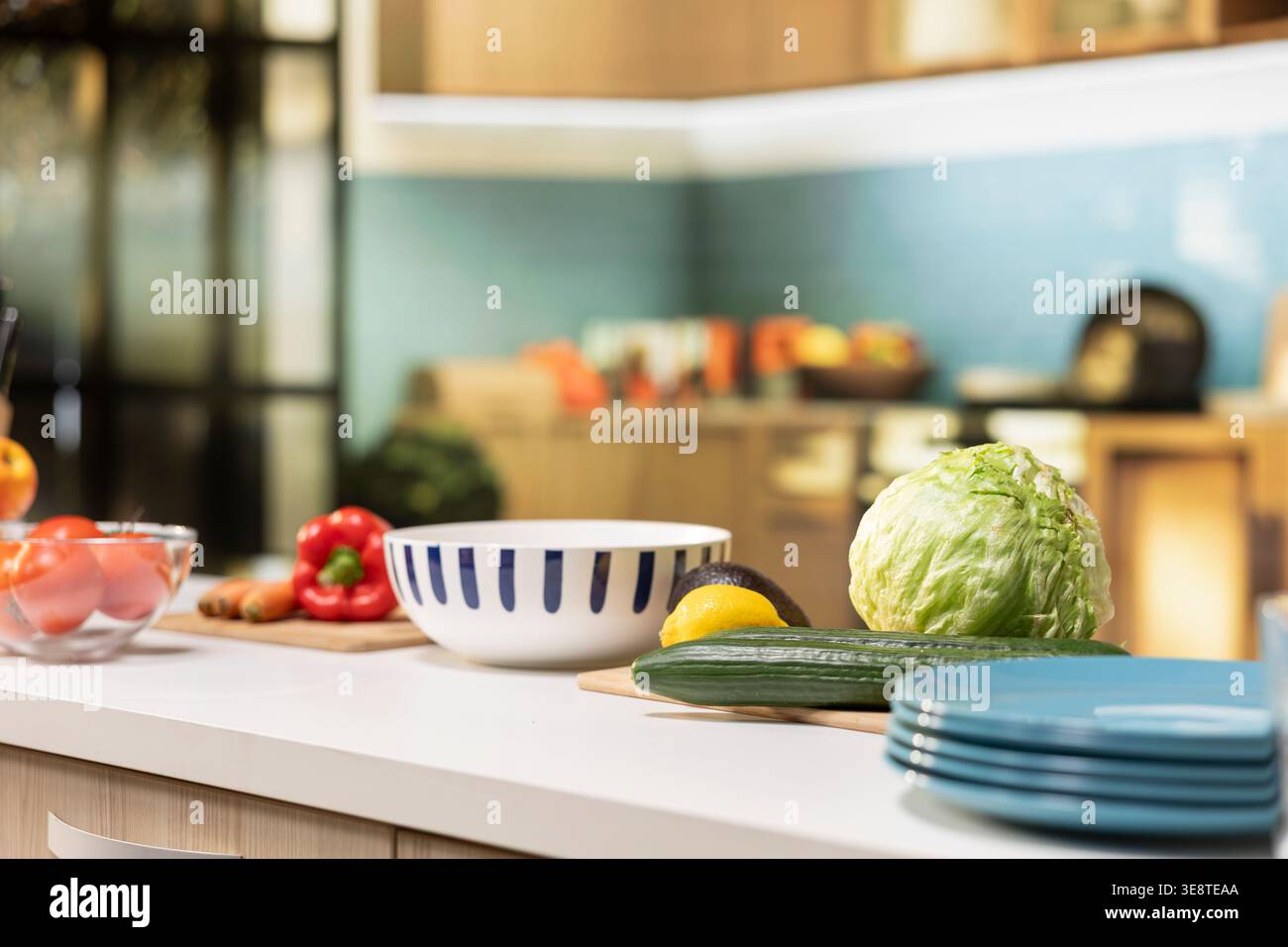Luxury kitchen with modern furniture and elegant decorations. Home interior features a countertop with organic produce, utensils and cooking essentials. Rustic charm and comfortable living. Stock Photo