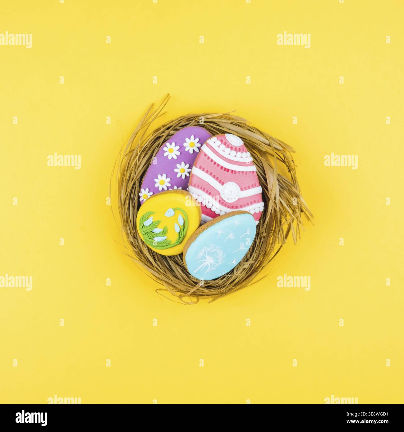 Nest with Easter eggs on a yellow background. Cookies decorated with Easter eggs. Stylish background for Easter Stock Photo