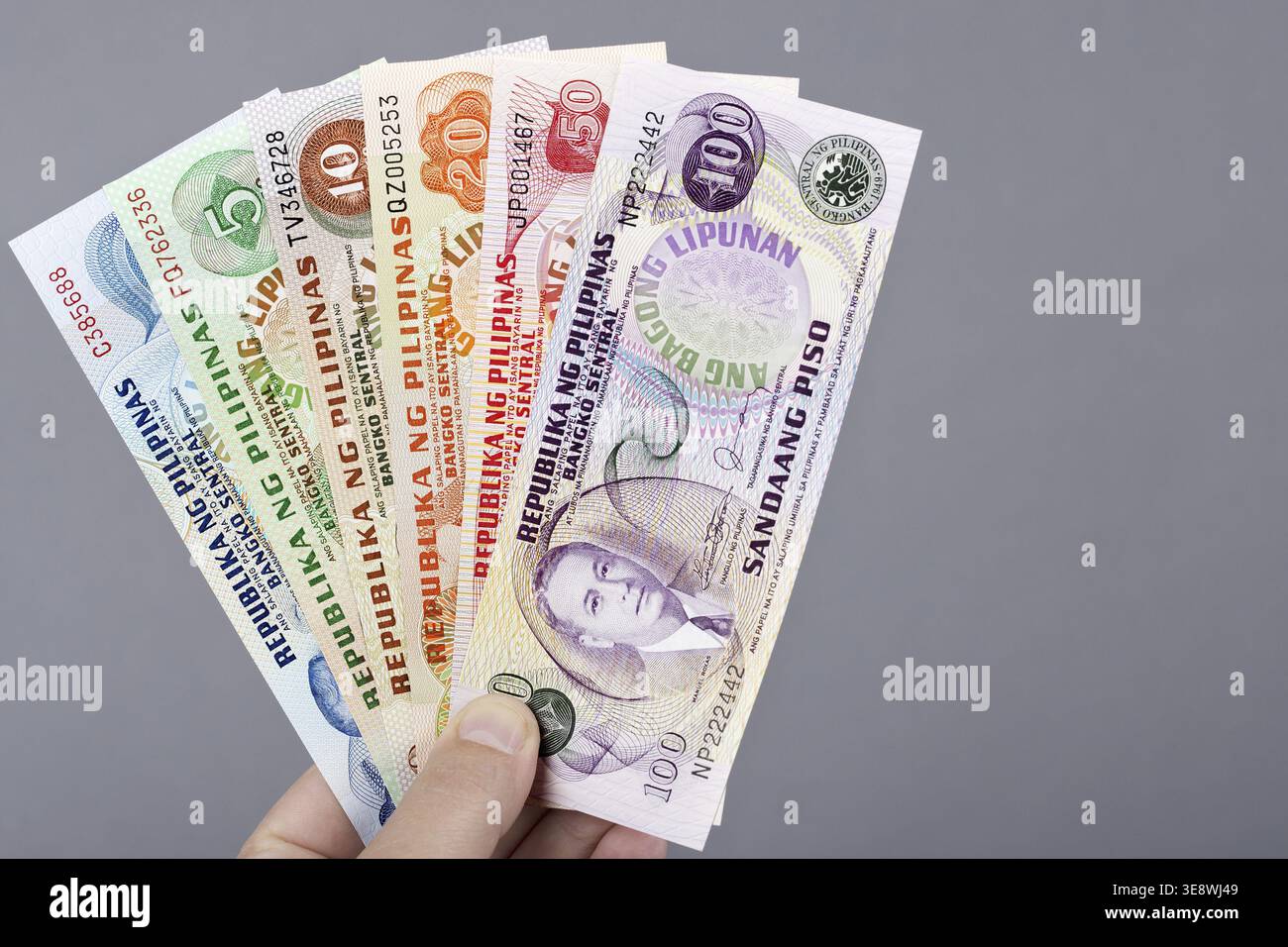 Old Philippine money - peso in the hand on a gray background Stock Photo