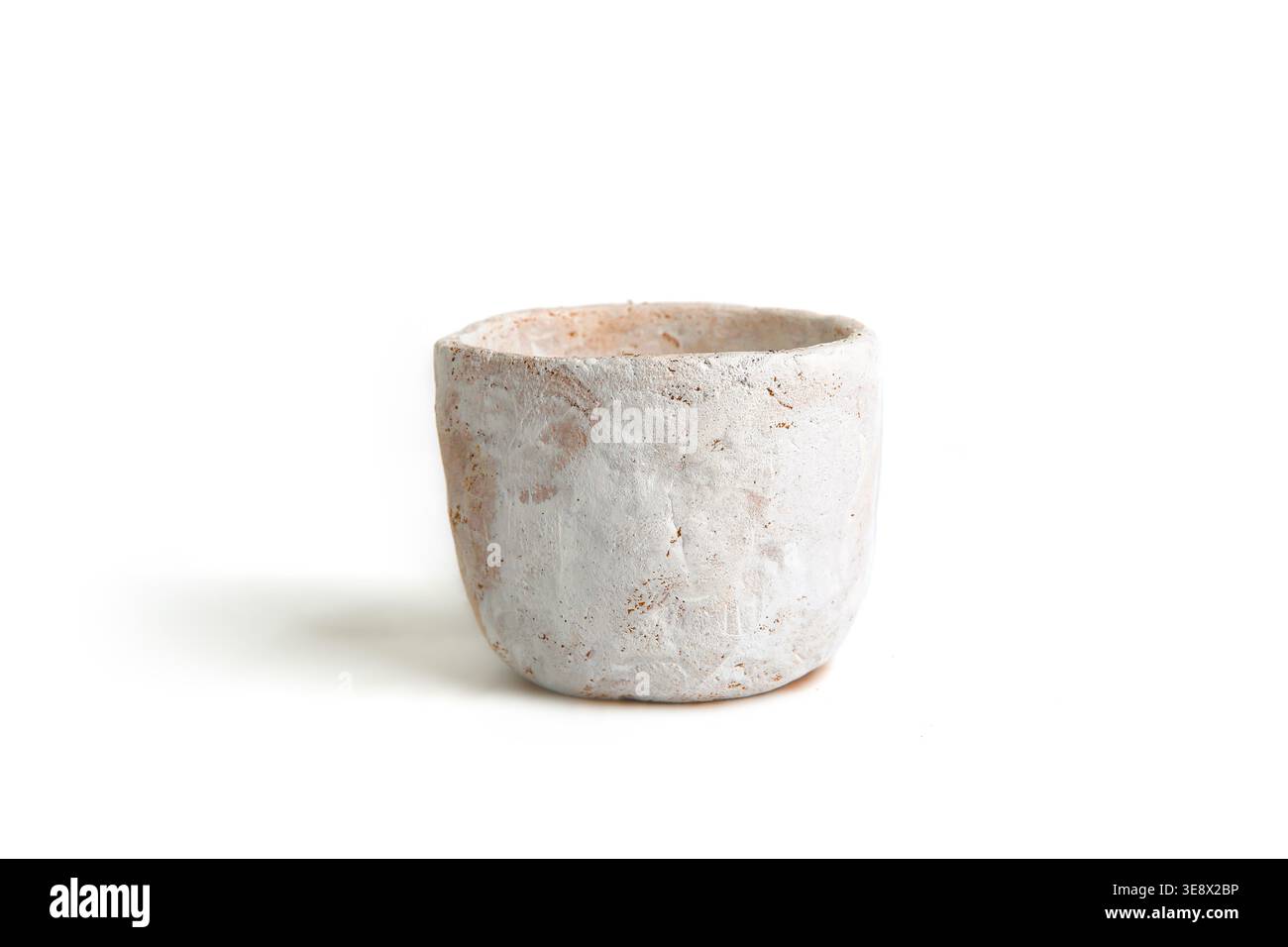 Handmade small clay pot isolated on white background. Empty white molded clay vase. Stock Photo