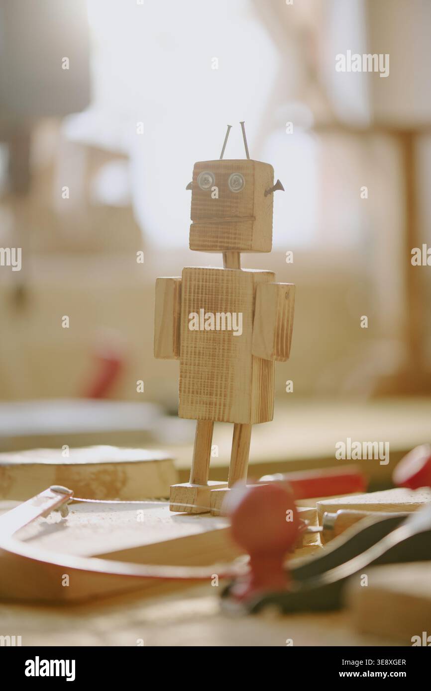 Wooden Robot Figure Standing on Workbench for Stem Learning Stock Photo