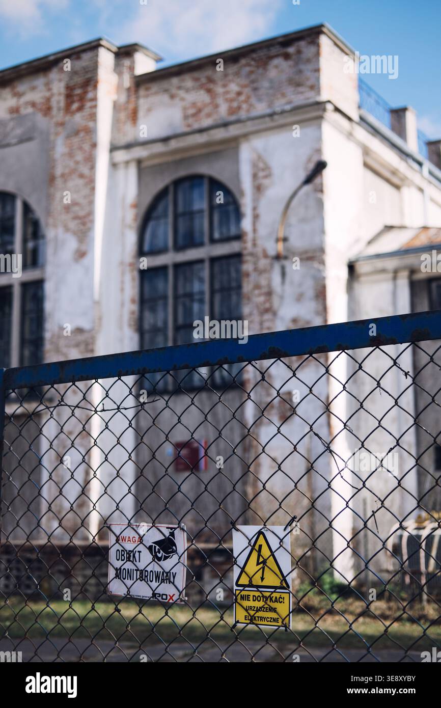 Warning Sign Property Risk warning signs stands before old industrial building. Vacant property ...