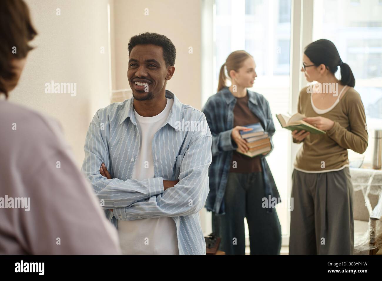 Black Adult Man Networking with Students in Learning Space Stock Photo