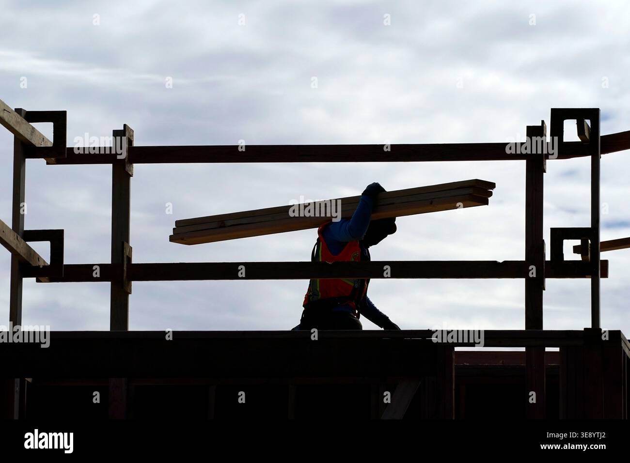 A construction worker moves lumber at a USA Properties Fund site ...