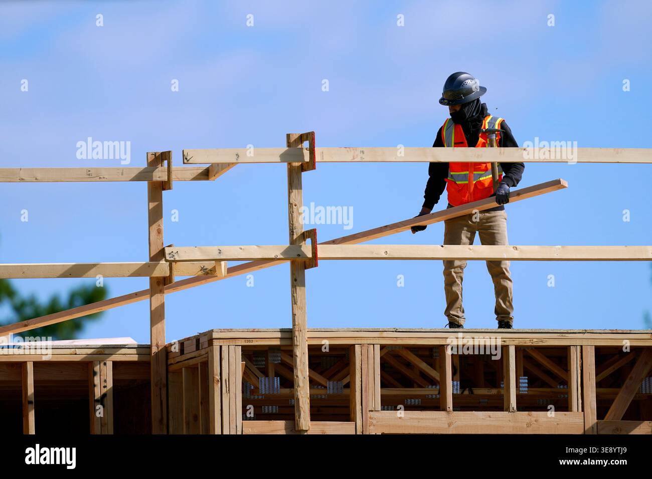 A construction worker moves lumber at a USA Properties Fund site ...
