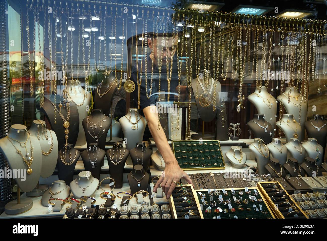 A goldsmith arranges the window of his gold shop in downtown Tehran ...