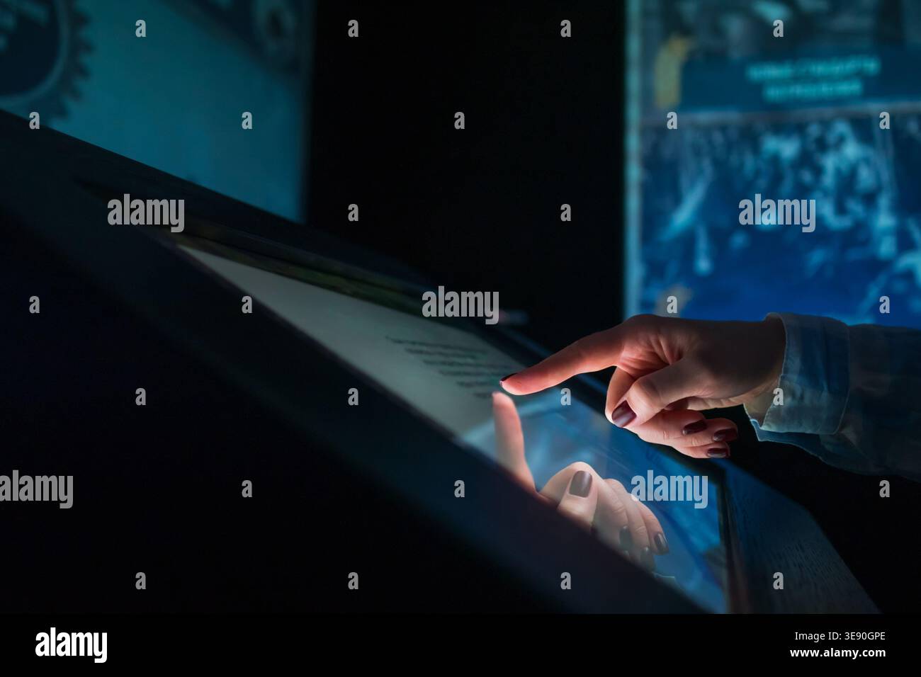 Woman using multimedia touchscreen display of interactive kiosk Stock Photo