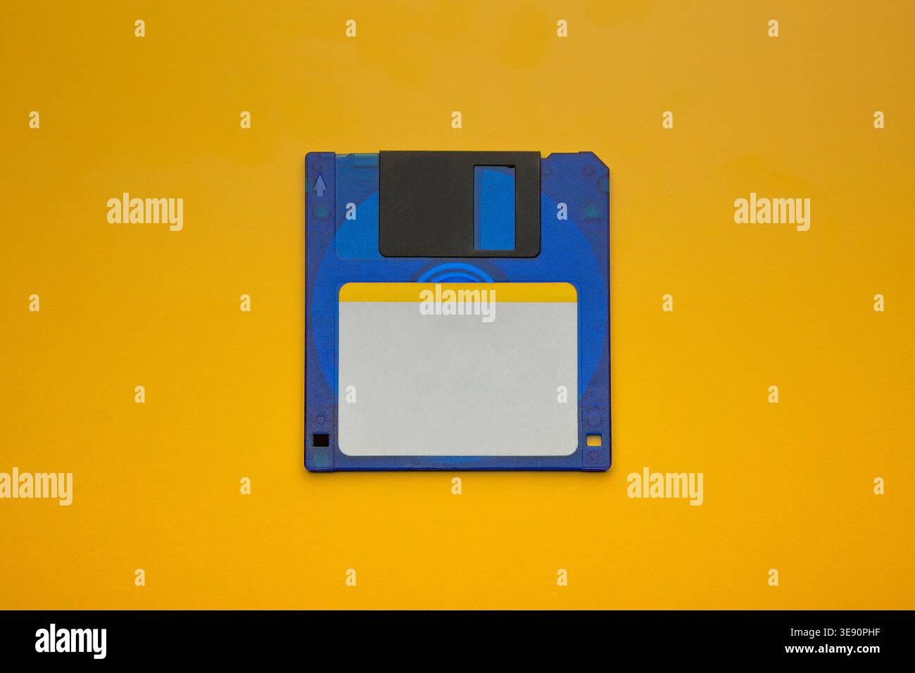 Blue floppy disk centered on yellow background Stock Photo