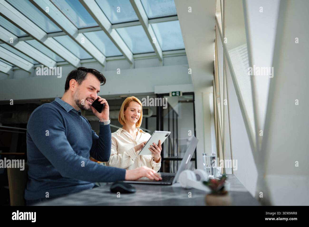 Business colleagues collaborating using technology in modern office space Stock Photo