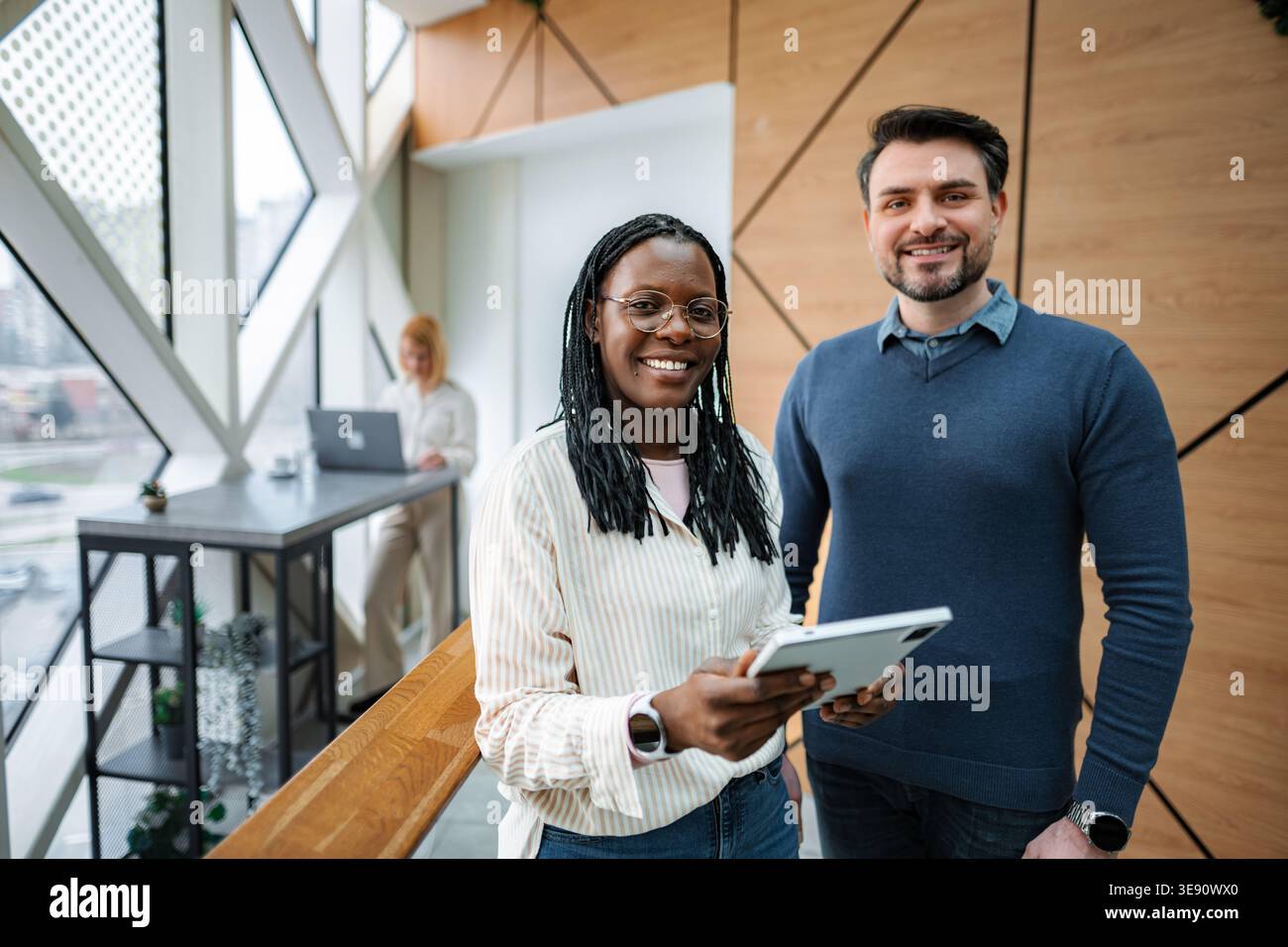 Diverse business professionals smiling, collaborating in modern office Stock Photo