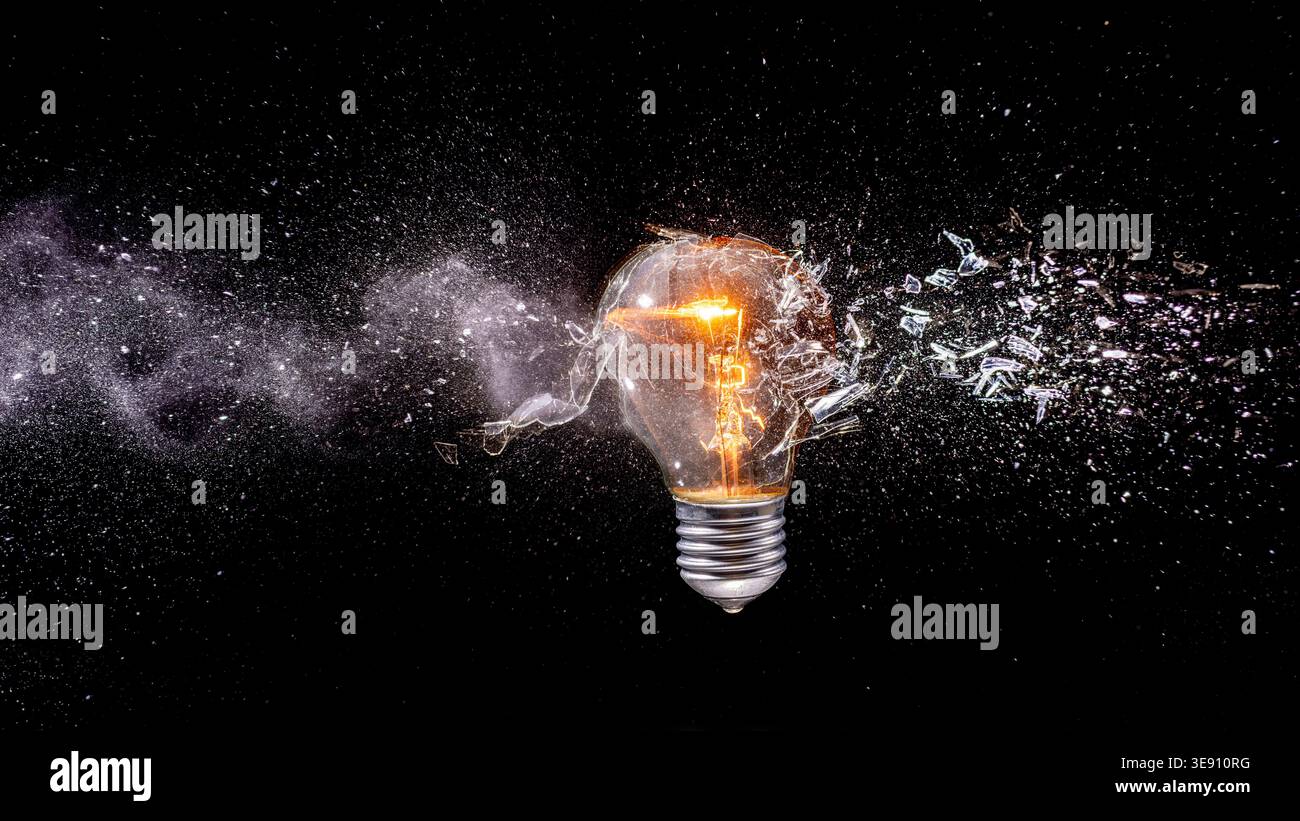 Real Light bulb shattering dark background Stock Photo