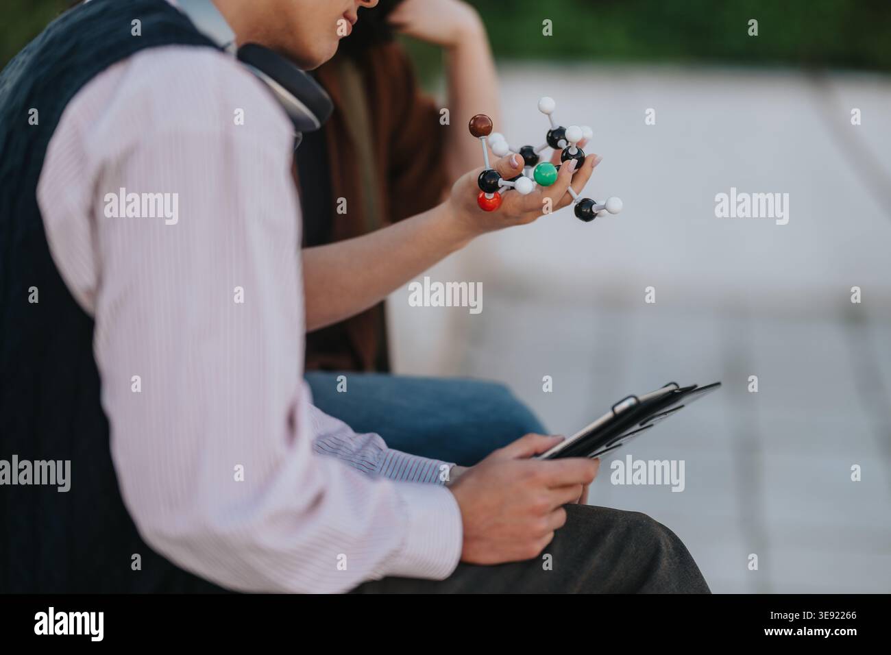Two students examining a molecular model while studying chemistry together on campus Stock Photo